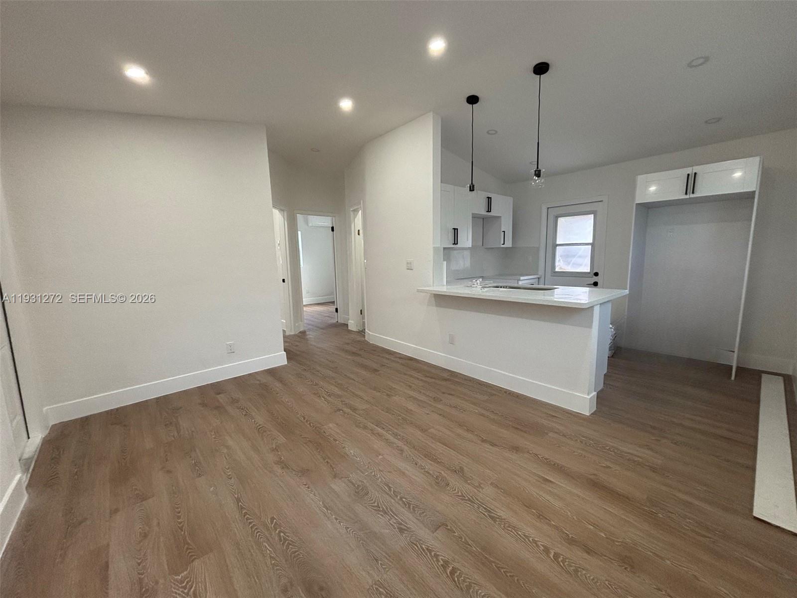 2838 Northwest 4th Street Pompano Beach, FL 33069 - Photo 4 of 10 wooden floor in an empty room with a kitchen