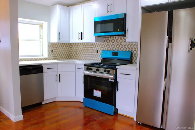 a kitchen with stainless steel appliances a stove a microwave and a sink