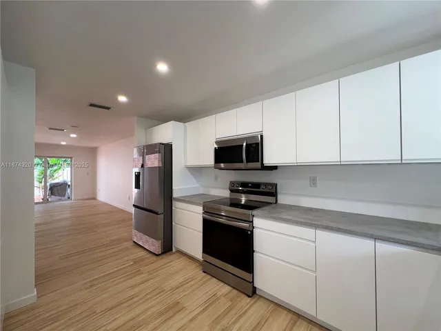 a large kitchen with stainless steel appliances kitchen island a large counter top
