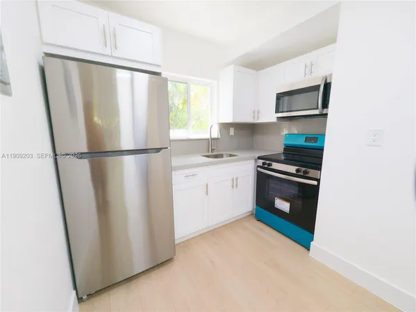 a kitchen with a refrigerator sink stove and cabinets