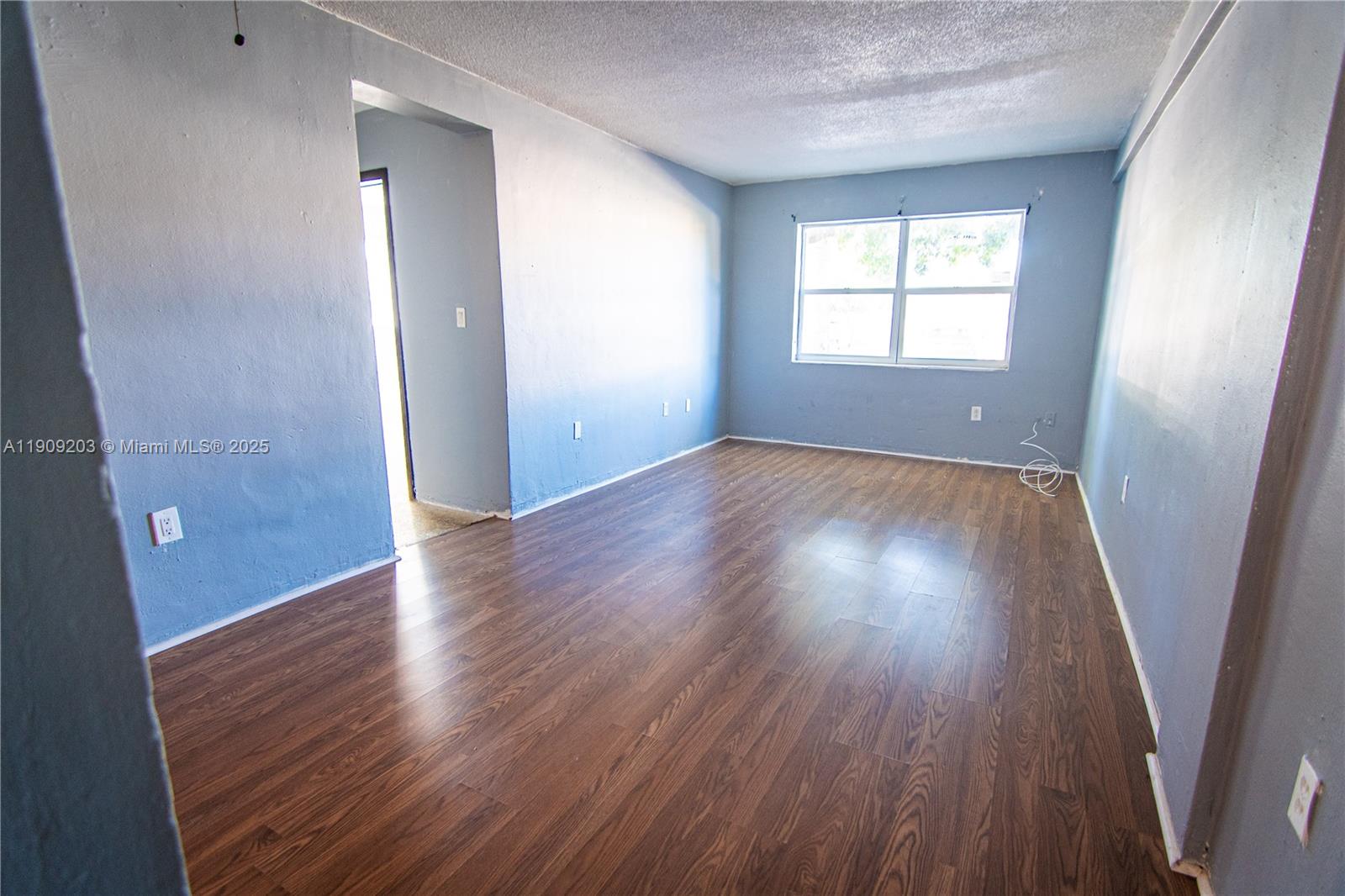 2000 Northwest 29th Street, Unit 1 Miami, FL 33142 - Photo 2 of 9 an empty room with wooden floor and windows