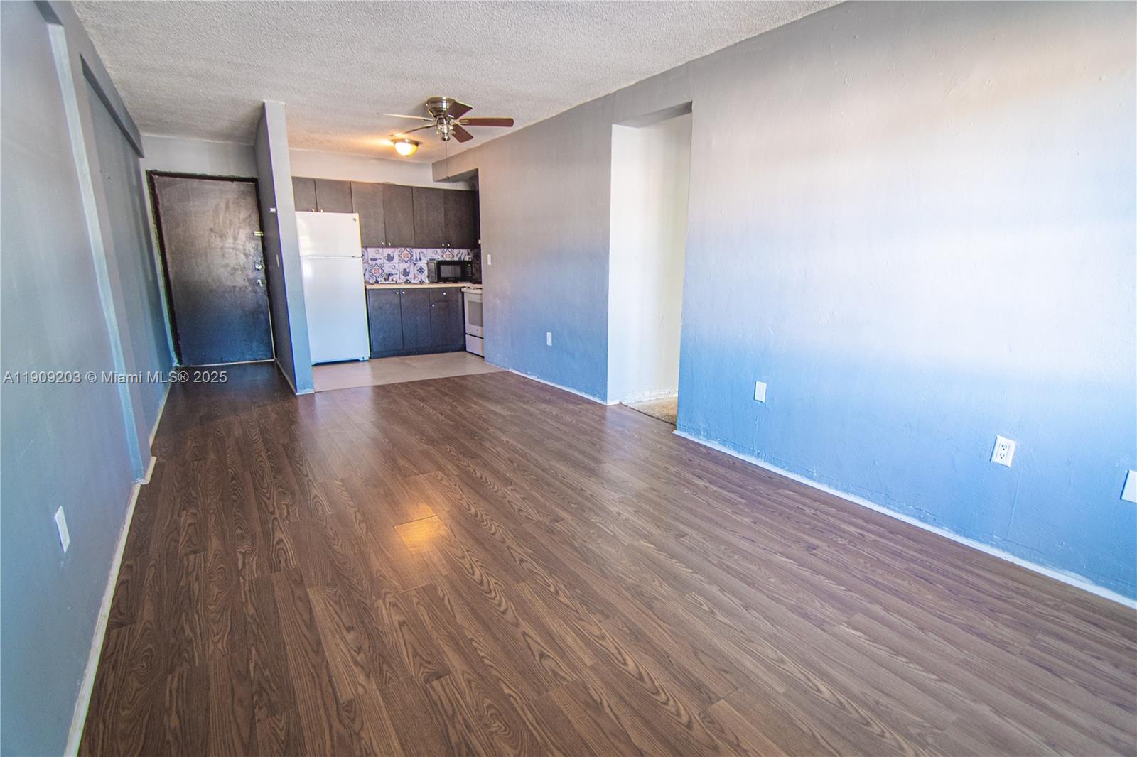 2000 Northwest 29th Street, Unit 1 Miami, FL 33142 - Photo 3 of 9 a view of a kitchen with a wooden floor and stainless steel appliances
