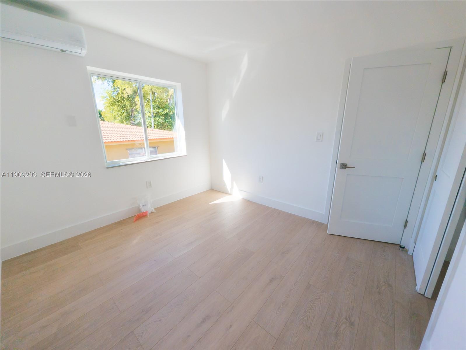 2000 Northwest 29th Street, Unit 1 Miami, FL 33142 - Photo 6 of 7 an empty room with wooden floor and windows