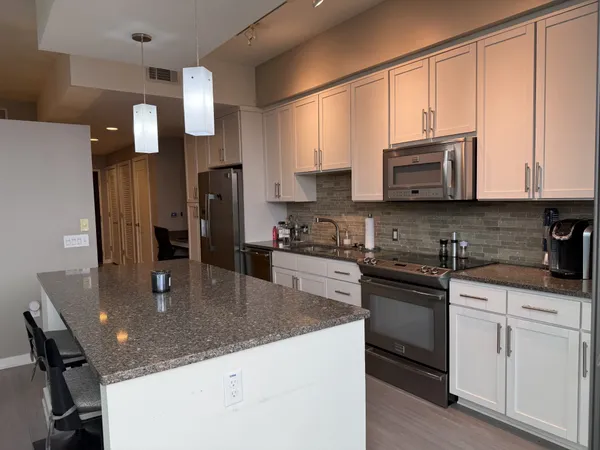 a kitchen with stainless steel appliances granite countertop a sink refrigerator and microwave