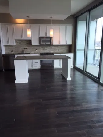 a kitchen with stainless steel appliances wooden floors and wooden cabinets