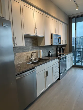 a kitchen with stainless steel appliances granite countertop a sink stove and microwave