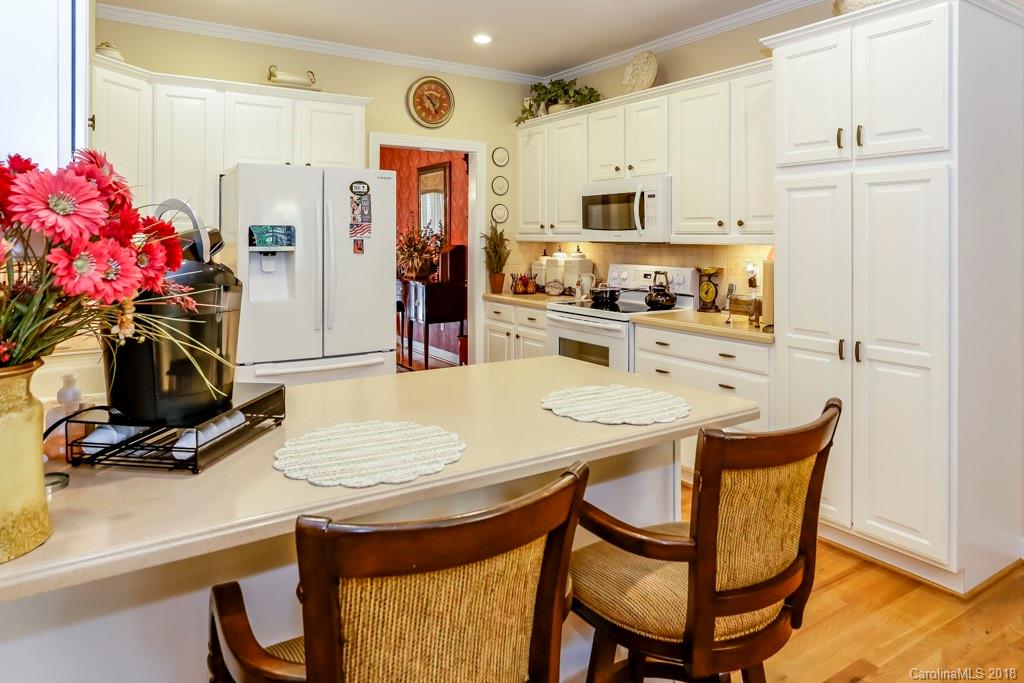321 Ridgeview Drive Rutherfordton, NC 28139 - Photo 7 of 25 a kitchen with stainless steel appliances kitchen island granite countertop a stove a refrigerator and a dining table with wooden floor