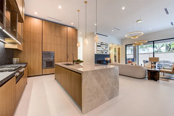 a large kitchen with stainless steel appliances a large counter top a stove a chimney a sink and a large window