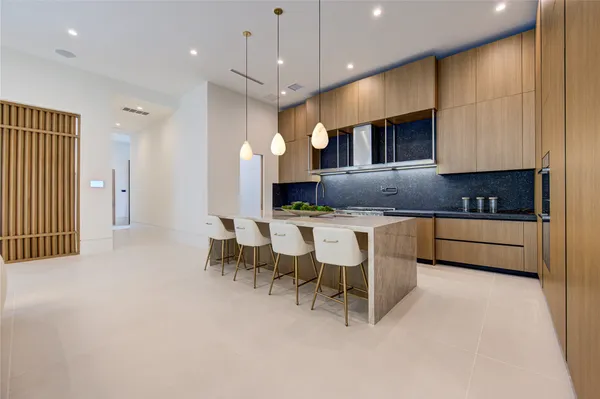 a kitchen with granite countertop a stove a sink a dining table and chairs