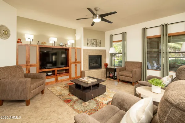 a living room with furniture a flat screen tv and a fireplace