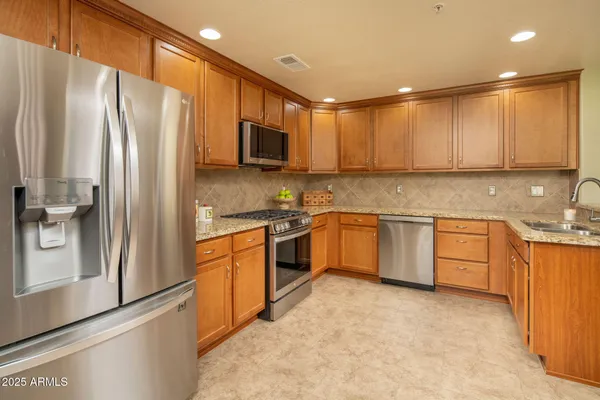 a kitchen with stainless steel appliances a refrigerator sink and cabinets