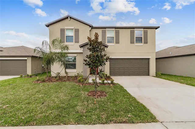 a front view of a house with a yard and garage