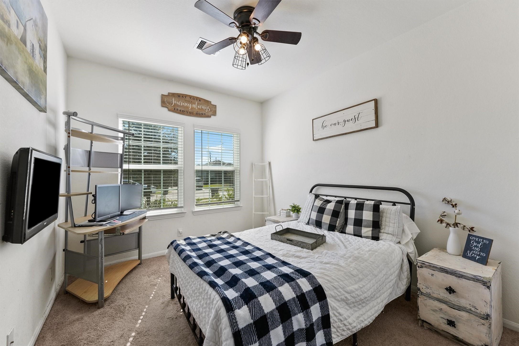 5303 Rivers Edge Drive Richmond, TX 77469 - Photo 2 of 8 a bedroom with a bed a dresser and a chandelier