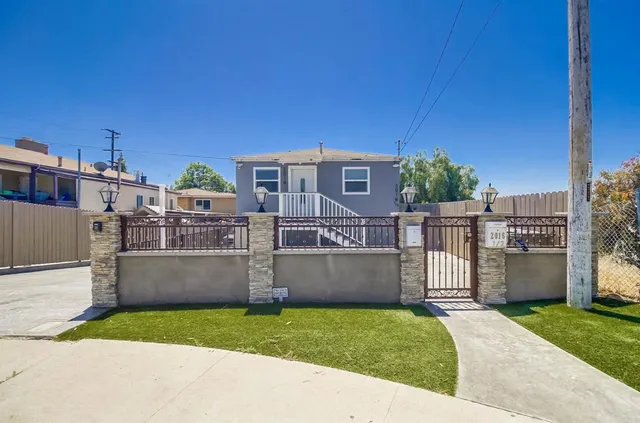 a front view of a house with a yard and a wooden fence