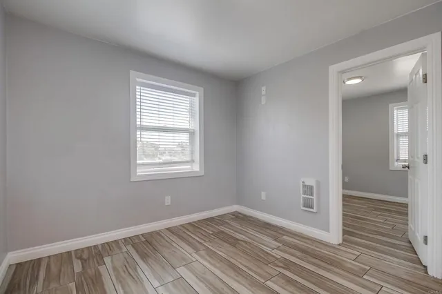 a view of empty room with wooden floor and windows