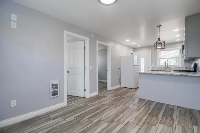 a kitchen with kitchen island white cabinets and wooden floor