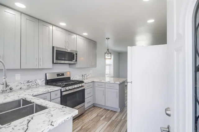 a kitchen with granite countertop a sink stainless steel appliances and cabinets