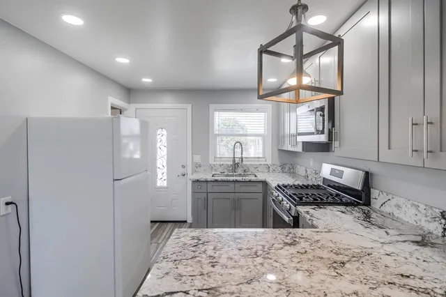 a bathroom with a granite countertop sink a toilet and mirror