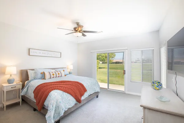 a bedroom with a balcony a bed and a chandelier