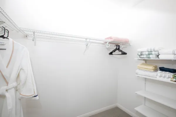 a view of walk in closet with empty racks