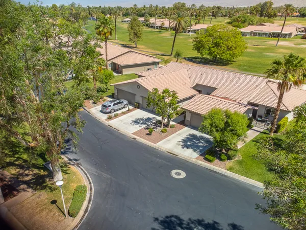 an aerial view of a house with a garden and lake view
