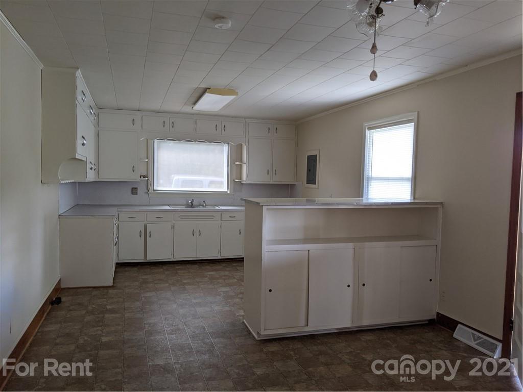 401 Gribble Road Matthews, NC 28104 - Photo 3 of 13 a kitchen with cabinets wooden floor and a sink