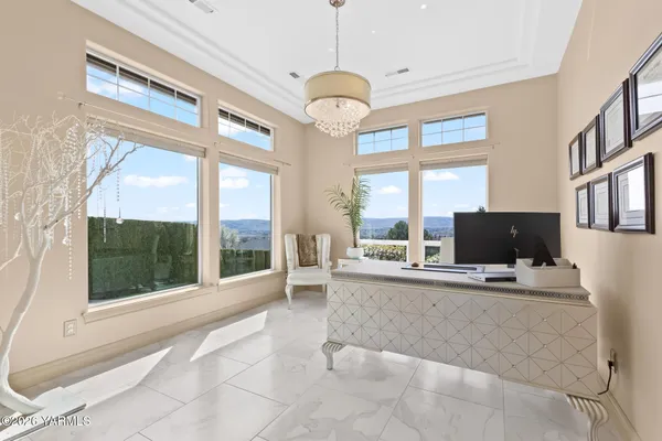 a living room with furniture a large window and a chandelier