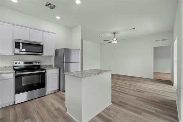 a kitchen with a refrigerator and a stove top oven