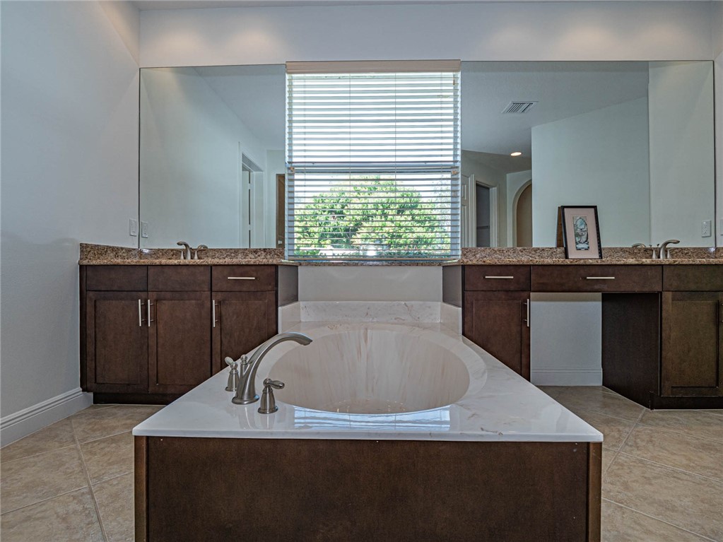 4229 Diamond Square Vero Beach, FL 32967 - Photo 24 of 36 a bathroom with a granite countertop sink a bathtub and window