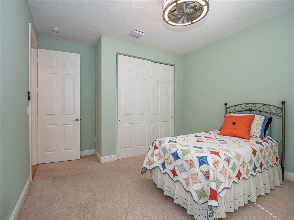 4229 Diamond Square Vero Beach, FL 32967 - Photo 27 of 36 a bedroom with a bed and a chandelier