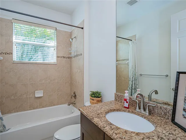 a bathroom with a granite countertop tub sink and mirror