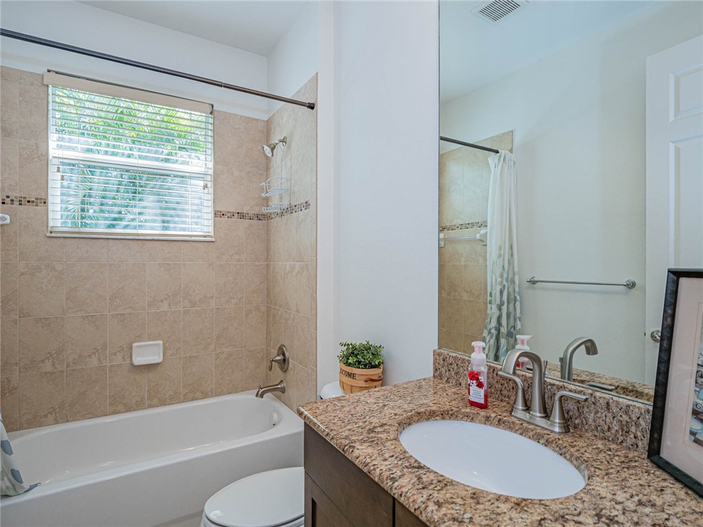 4229 Diamond Square Vero Beach, FL 32967 - Photo 28 of 36 a bathroom with a granite countertop tub sink and mirror