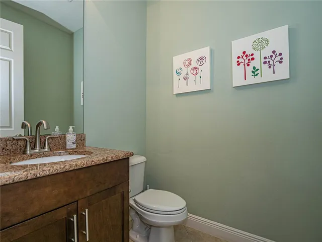 a bathroom with a granite countertop sink mirror vanity and toilet