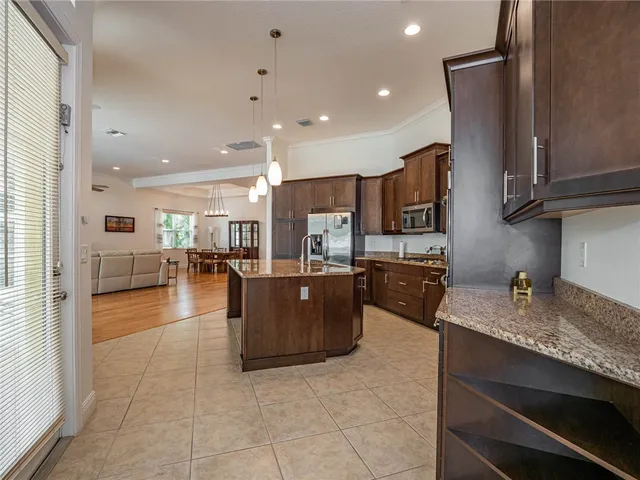 a kitchen with stainless steel appliances granite countertop a sink counter space and a view of living room