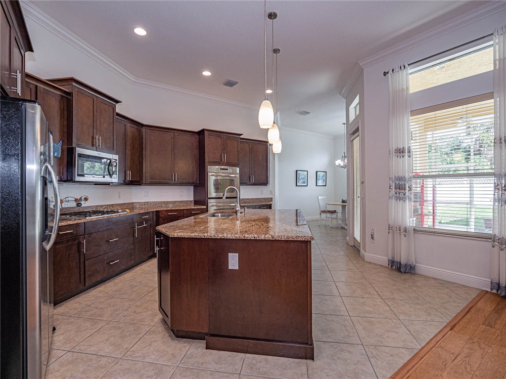 4229 Diamond Square Vero Beach, FL 32967 - Photo 9 of 36 a kitchen with kitchen island a stove a sink a refrigerator and a oven