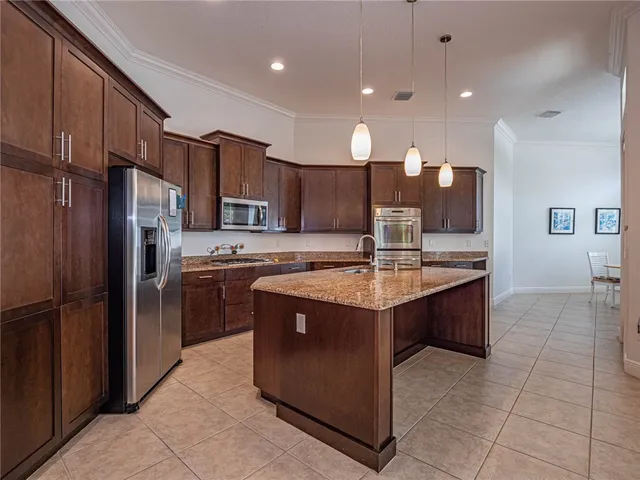 a kitchen with stainless steel appliances granite countertop a sink counter space cabinets and a refrigerator
