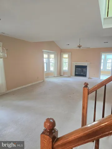 a view of an empty room with window and fireplace