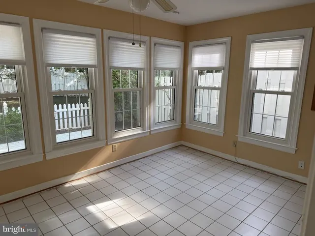 a view of a house with a small yard and wooden fence and a bench