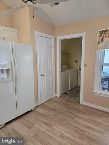 a view of an empty room with closet and a window