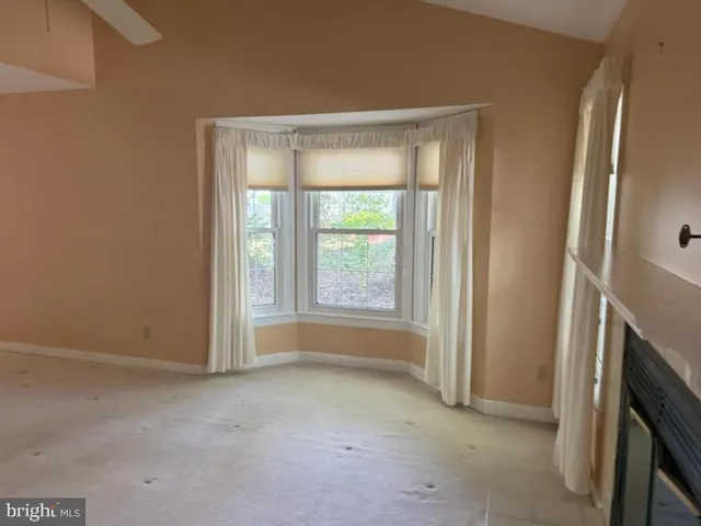 a view of an empty room with a fireplace and a window