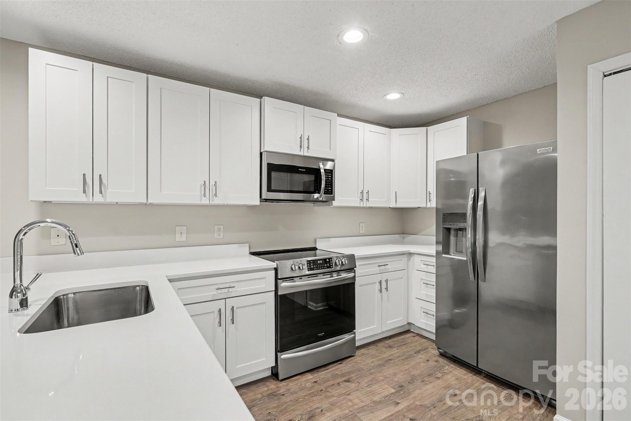 9060 Tulagi Court Tega Cay, SC 29708 - Photo 12 of 29 a kitchen with white cabinets and stainless steel appliances