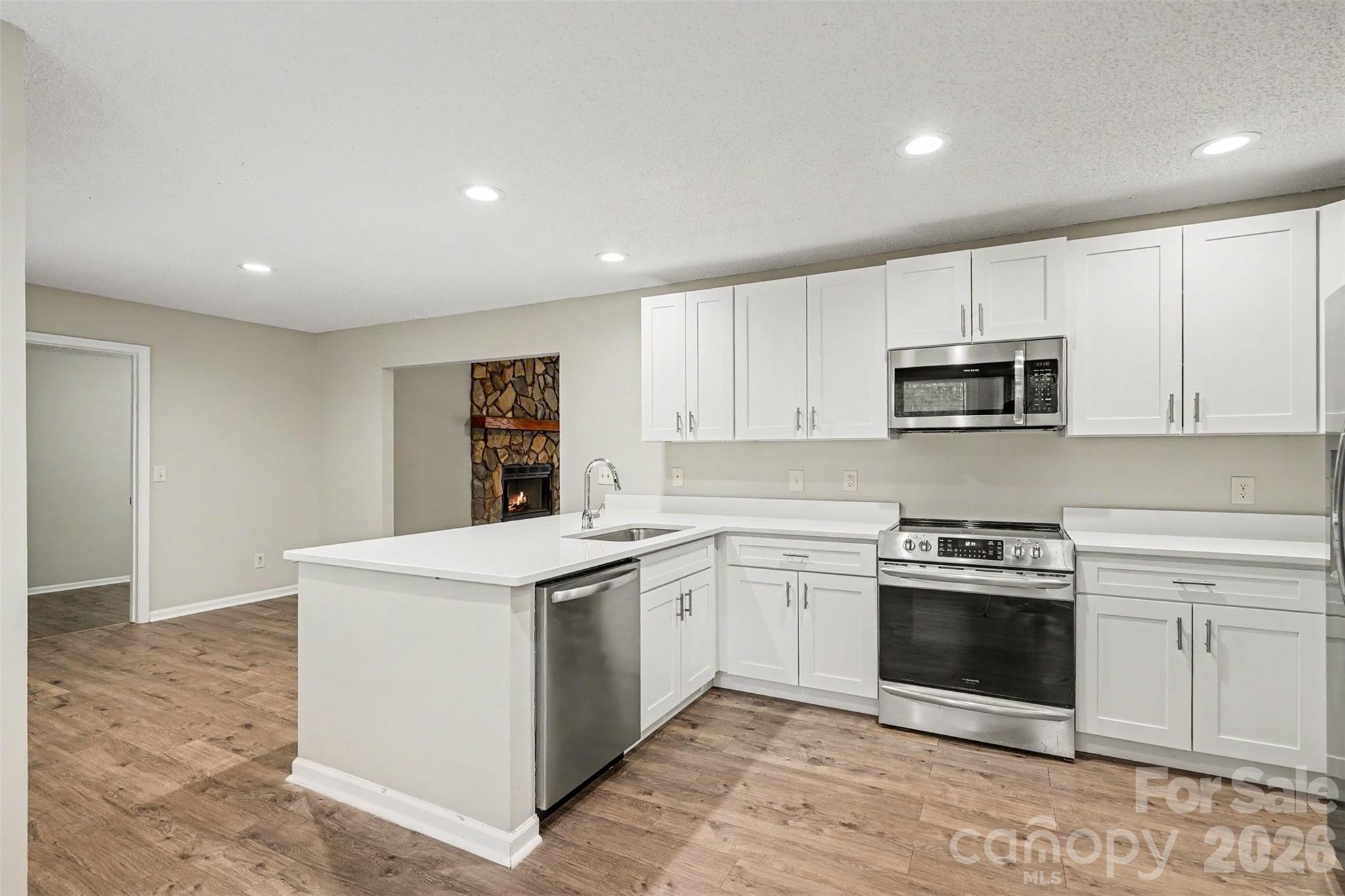 9060 Tulagi Court Tega Cay, SC 29708 - Photo 13 of 29 a kitchen with white cabinets stainless steel appliances and sink