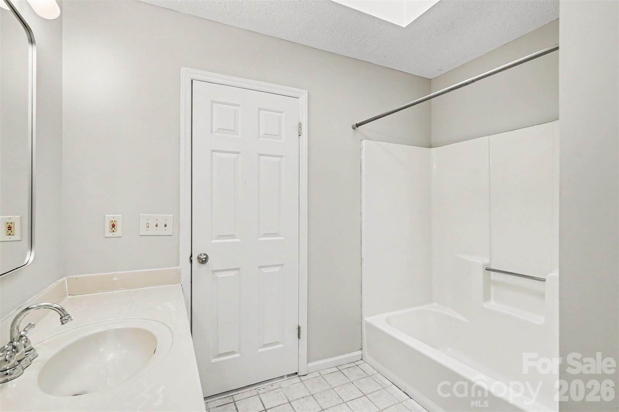 9060 Tulagi Court Tega Cay, SC 29708 - Photo 23 of 29 a bathroom with a sink a mirror and a bathtub