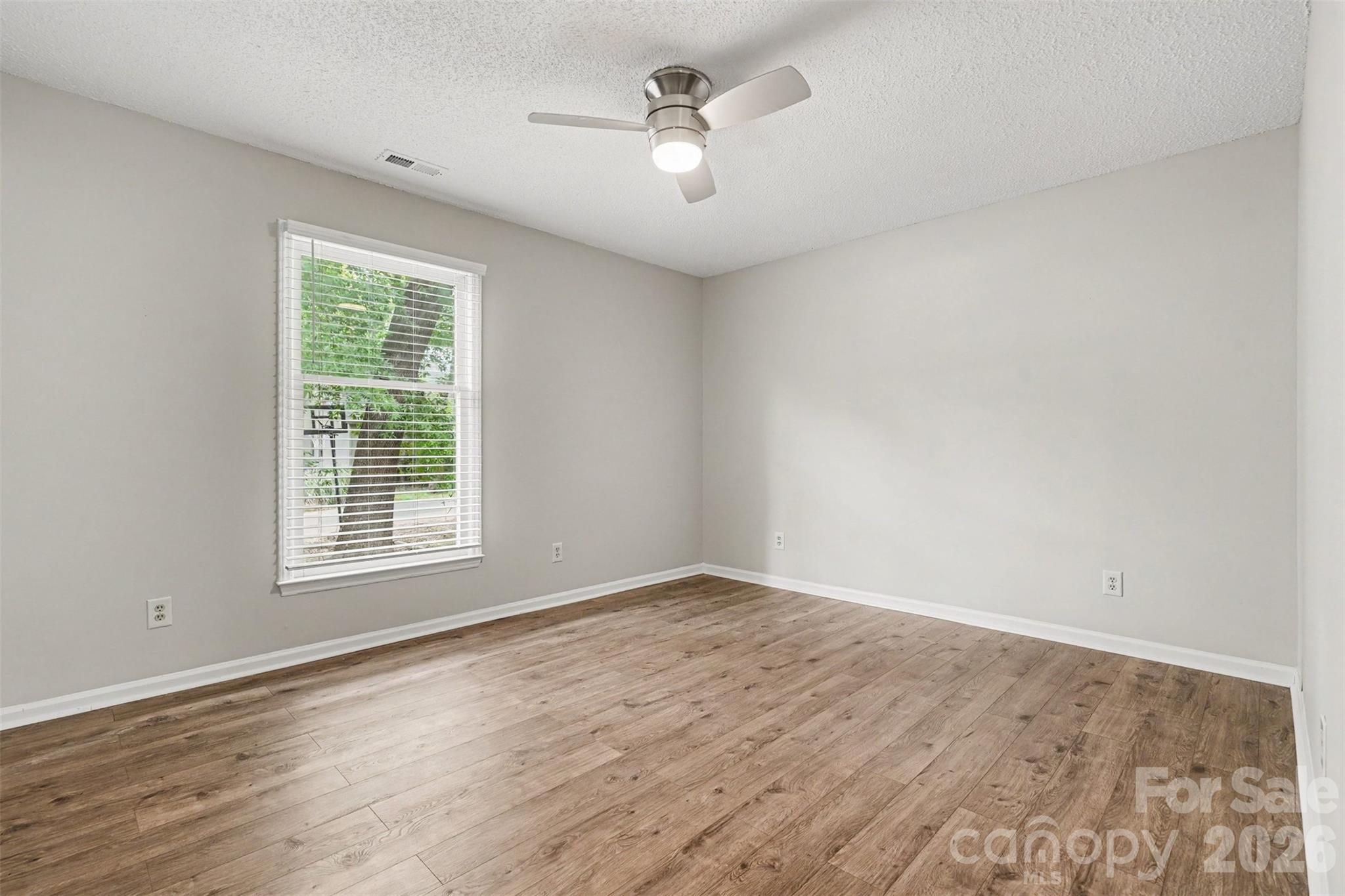 9060 Tulagi Court Tega Cay, SC 29708 - Photo 26 of 29 wooden floor in an empty room with a window