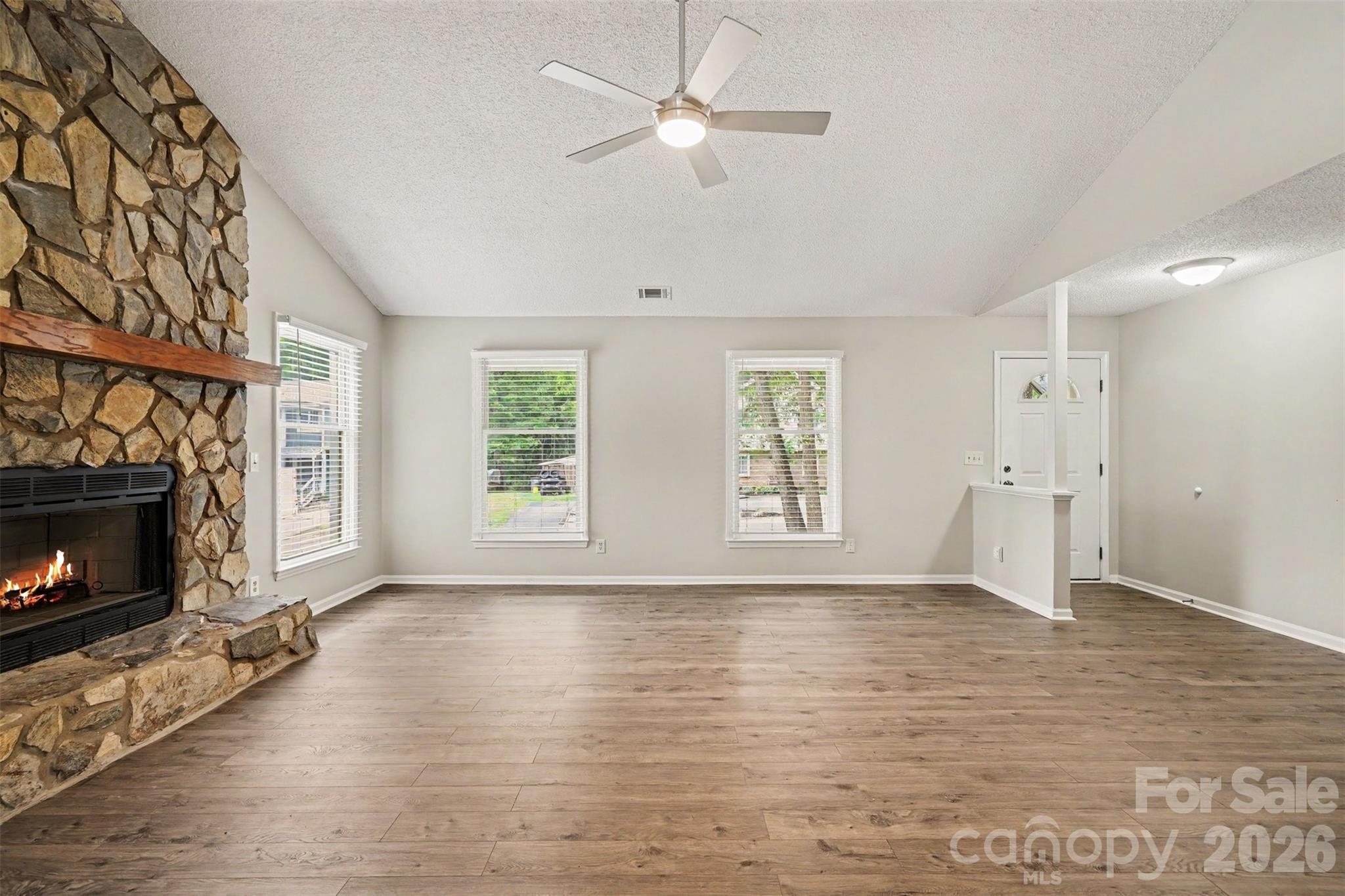 9060 Tulagi Court Tega Cay, SC 29708 - Photo 7 of 29 a view of wooden floor fire place refrigerator and window in a room