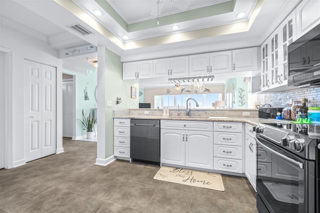 6399 Shoreline Drive, Unit 4206 St. Petersburg, FL 33708 - Photo 14 of 40 a kitchen with granite countertop cabinets and white stainless steel appliances