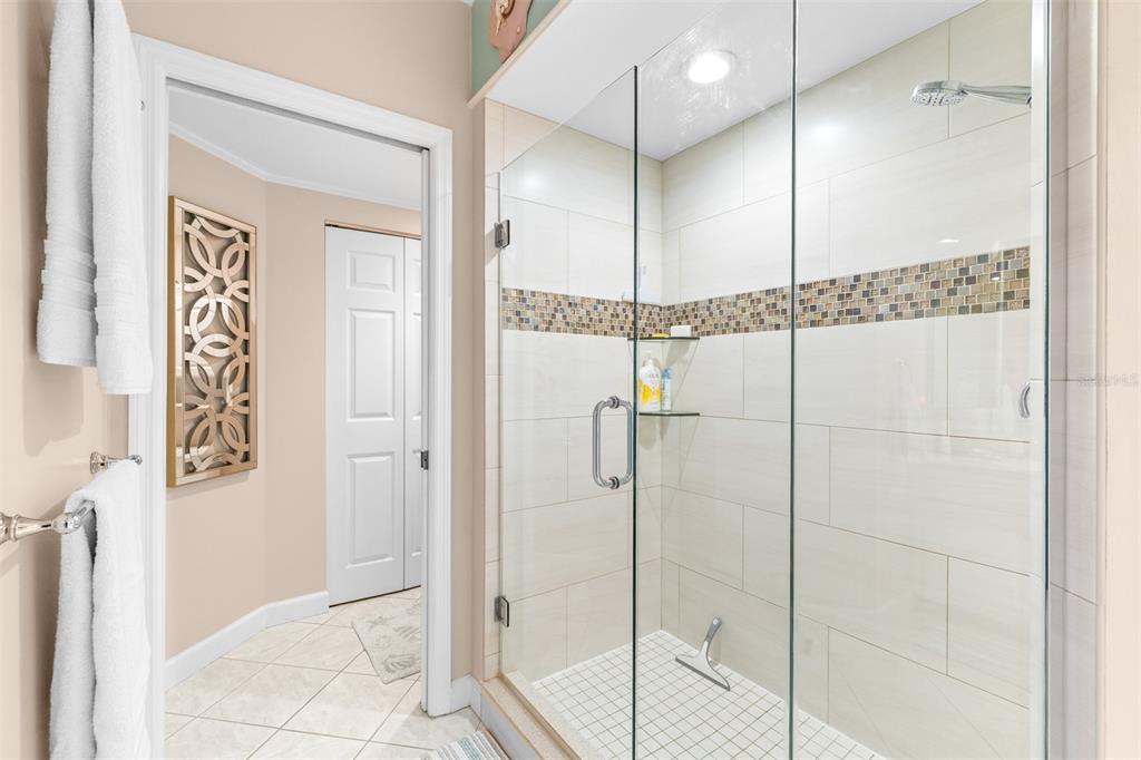 6399 Shoreline Drive, Unit 4206 St. Petersburg, FL 33708 - Photo 18 of 40 a bathroom with a glass shower door and a shower