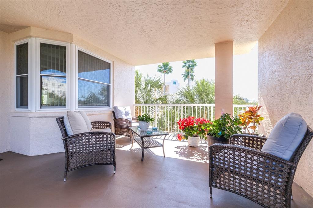 6399 Shoreline Drive, Unit 4206 St. Petersburg, FL 33708 - Photo 2 of 40 a balcony with furniture and flowers