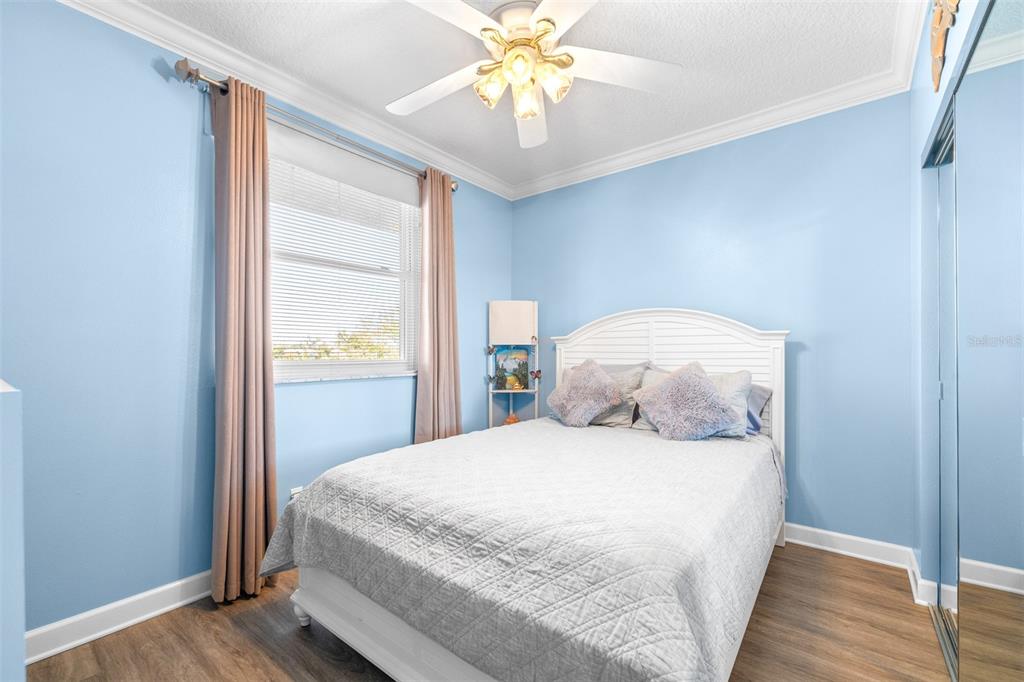 6399 Shoreline Drive, Unit 4206 St. Petersburg, FL 33708 - Photo 21 of 40 a bedroom with a bed and a chandelier