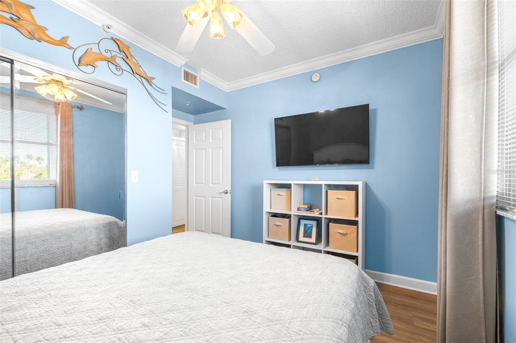 6399 Shoreline Drive, Unit 4206 St. Petersburg, FL 33708 - Photo 22 of 40 a bedroom with a bed and a flat screen tv
